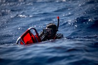 Andrew Gabris swims with a stretcher during a search and rescue training exercise near the Wasp-class amphibious assault ship USS Kearsarge (LHD 3) July 17, 2022. 