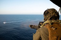 U.S. Marine Corps Cpl. Charles McKellar, a crew chief with the Aviation Combat Element, 22nd Marine Expeditionary Unit (MEU), shoots a minigun from the back of a UH-1Y Huey during a live-fire exercise over the Atlantic Ocean, July 15, 2022. The Kearsarge Amphibious Ready Group and embarked 22nd MEU, under the command and control of Task Force 61/2, is on a scheduled deployment in the U.S. Naval Forces Europe area of operations, employed by U.S. Sixth Fleet to defend U.S., Allied and Partner interests. (U.S. Marine Corps photo by Cpl. Yvonna Guyette)