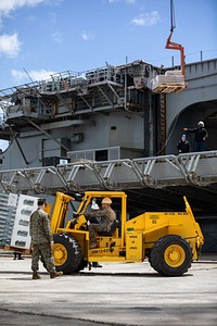 Marines and Sailors load supplies onboard the Wasp-class amphibious assault ship USS Kearsarge (LHD 3), during mid-deployment voyage repairs in Brest, France, June 30, 2022. The Kearsarge Amphibious Ready Group and embarked 22nd Marine Expeditionary Unit, under the command and control of Task Force 61/2, is on a scheduled deployment in the U.S. Naval Forces Europe area of operations, employed by U.S. Sixth Fleet to defend U.S., allied and partner interests. (U.S. Navy photo by Mass Communication Specialist 3rd Class Jesse Schwab)