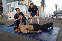 GULF OF ADEN (June 20, 2022) Senior Chief Master-at-Arms Brandon Spears, top, from Corona, California, observes as Seaman Najma Mohamoud, from Columbus, Ohio, performs a mock take-down on Culinary Specialist 1st Class Bryan Hairiston, from Damville, Virginia, during security reaction force training aboard the Lewis B. Puller-class expeditionary sea base USS Hershel "Woody" Williams (ESB 4), June 20, 2022. Hershel “Woody” Williams is rotationally deployed to the U.S. Naval Forces Africa area of operations, employed by U.S. Sixth Fleet, to defend U.S., allied and partner interests. (U.S. Navy photo by Mass Communication Specialist 1st Class Fred Gray IV/Released)