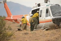 A Wolf Creek hotshot boards a helicopter while aircrew members load equipment July 27, 2022, headed out to a remote wilderness area affected by the Dodge Springs Fire. Photo by Jess D. Harvey/USDA Forest Service