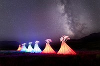 Illuminated teepees and Milky Way at North Entrance in Gardiner, Montana.