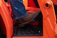 Driving tractor, farmer's foot.