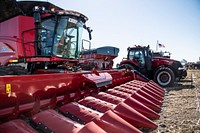 Combine harvester and a tractor with a grain cart are equipped with an autonomous control system by Raven Industries who are showcasing some of their autonomous agricultural solutions at the Farm Progress show in Boone, IA, on August 31, 2022.To address human and economic resource shortages, they are utilizing autonomy, wireless connectivity, sub-inch GPS accuracy, sensor technology, data-based information, control and guidance systems, and more to make existing farm tractors with grain carts more efficient. Here, farm equipment has been retrofitted to add autonomous control from a smart tablet. With a single button push, tractors pulling grain carts can be summoned into precise alignment and movement next to a moving harvester to increase safety and efficiency and reduce spillage. Autonomous equipment, equipped with sensors, cameras, and specialized controls, can operate in a field where other operators work and recognize fields not yet harvested and harvested. The black OMNiPOWER 3200 is an autonomous driverless cab-less applicator spreader, 120-food boom sprayer, and air seeder programed or controlled by a smart tablet. Its safety systems allow it to work in occupied fields. The four-wheel hydraulic drive and steer systems can utilize front, rear, or four-wheel steering to turn on a dime. USDA media by Lance Cheung.