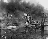 Naval photograph documenting the Japanese attack on Pearl Harbor, Hawaii which initiated US participation in World War II. Navy's caption: The twisted remains of the destroyer USS SHAW burning in floating drydock at Pearl Harbor after the "sneak Japanese attack" on Dec. 7, 1941., 12/07/1941.