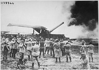 Discharge of a huge French cannon caught by the camera just as the projectile left for the German lines. The gunners have stuffed their fingers into their ears to protect them from noise of explosion. Underwood and Underwood., ca. 1918. Original public domain image from Flickr