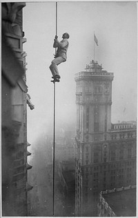 The "Human Squirrel" who did many daring "stunts" in climbing for benefit of War Relief Funds in New York City. He is shown here at a dizzy height in Times Square. Times Photo Service., ca. 1918. Original public domain image from Flickr