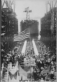 Launching the Quistconck, first completed at Hog Island shipyards. The President and Mrs. Wilson are standing on the platform on opposite sides of the flagpole. Mrs. Wilson christened the vessel., ca. 1918. Original public domain image from Flickr