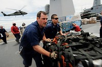 U.S. Navy Hull Technician 2nd Class Seneca Jernigan, left, and Yeoman 3rd Class Steven Tai move pallets of humanitarian assistance disaster relief (HADR) kits across the flight deck of the U.S. 7th Fleet command flagship USS Blue Ridge (LCC 19) during an underway replenishment with the fleet replenishment oiler USNS Rappahannock (T-AO 204) as part of Operation Tomodachi in the South China Sea, March 12, 2011.