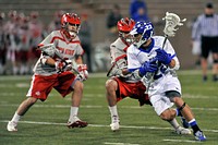 Adam Paranka, a junior attacker on the U.S. Air Force Academy Falcons lacrosse team, in blue, maneuvers around Ohio State Buckeyes defensemen during a home game April 17, 2011, in Colorado Springs, Colo. The Falcons lost 8-4 to their Eastern College Athletic Conference (ECAC) rival.