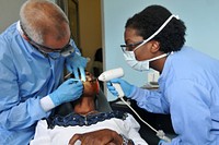 Lilongwe, Malawi - Col. Sheldon "Shel" Omi and Staff Sgt. Amy L. Montgomery provide free dental care to a Malawian patient. While in Malawi to support the joint humanitarian exercise MEDREACH 11, the Airmen volunteered at the Partners in Hope Medical Centre to provide free dental care to local civilians. MEDREACH is a key program in the United States&rsquo; efforts to partner with the Government of Malawi. (Photo by Sgt. Jesse Houk, 139th MPAD, Illinois Army National Guard). Original public domain image from Flickr