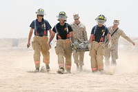 Emergency Services personnel at Camp Leatherneck, Afghanistan, treat a simulated casualty during a mass casualty evacuation exercise at the Leatherneck Burn Pit Aug. 6, 2011.