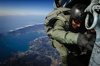 A member of the Italian Navy's Gruppo Operativo Incursori prepares to exit an U.S. Navy MH-60S Knight Hawk helicopter, assigned to Helicopter Sea Combat Squadron 28 (HSC-28) Detachment 1, during military free fall training over the Gulf of La Spezia, March 15, 2012.