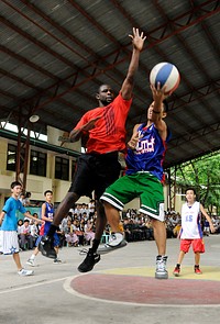 U.S. Navy Intelligence Specialist 1st Class Shadaron Odom, left, attempts to block a shot during a basketball game March 26, 2012, at Taguig National High School in Taguig City, Philippines.