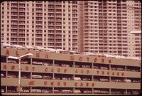 Every foot of space must count on the island: 4-decker car dealer's showroom and high-rise apartments, October 1973. Photographer: O'Rear, Charles. Original public domain image from Flickr