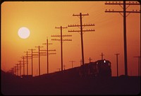 Railroad and transmission lines near Salton Sea. Hazy sun is caused by distant Los Angeles smog, May 1972. Photographer: O'Rear, Charles. Original public domain image from Flickr