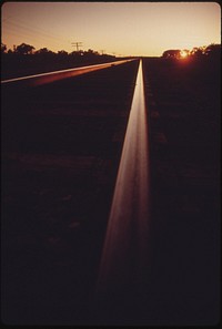 Empty rails of the main line of the Atchison, Topeka and Santa Fe railroad that carries the Southwest Limited near Dodge City, Kansas, June 1974. Original public domain image from Flickr