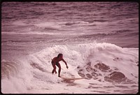 Surfer at Newport Beach, a heavily used recreation spot, May 1975. Photographer: O'Rear, Charles. Original public domain image from Flickr