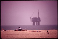 Sunbathers at Huntington Beach, and an oil platform offshore, May 1975. Photographer: O'Rear, Charles. Original public domain image from Flickr