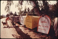 Clustered mailboxes help the mailman whose route takes him to the Malibu Lake area in the Santa Monica Mountains near Malibu California, May 1975. Photographer: O'Rear, Charles. Original public domain image from Flickr