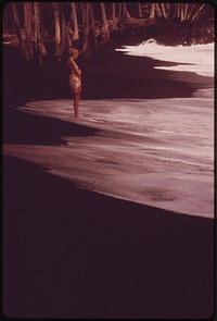 Famous Black Sand Beach at Kaimu, created by lava runoff, is a favorite tourist stop, November 1973. Photographer: O'Rear, Charles. Original public domain image from Flickr