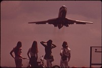 One Of The Bicyclists Holds Her Ears Against The Roar Of The Jet, Taking Off From National Airport, May 1973. Original public domain image from Flickr