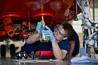 U.S. Coast Guard Airman Lucas Dellams takes fuels sample from an HH-65B Dolphin helicopter during a routine maintenance inspection at Coast Guard Air Station Kodiak, Alaska, June 26, 2012.