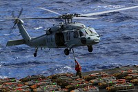 U.S. Sailors aboard the aircraft carrier USS Enterprise (CVN 65) attach pallets of ammunition to an MH-60S Knighthawk helicopter assigned to Helicopter Sea Combat Squadron (HSC) 28 in the Atlantic Ocean Oct. 25, 2012.