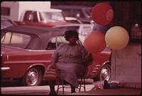 Black Woman Selling Gas Filled "Have A Happy Day" Balloons On A Chicago South Side Street Corner At Sox Park Baseball Field, 06/1973. Photographer: White, John H. Original public domain image from Flickr