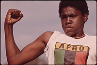 A Young Black Man Showing His Muscle During A Small Community Program In Chicago On The South Side, 08/1973. Photographer: White, John H. Original public domain image from Flickr