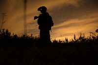 A U.S. Navy SEAL scans a field for simulated enemy threats during Operation Urban Corkscrew as part of Emerald Warrior 2013 at Camp Shelby, Miss., April 29, 2013.