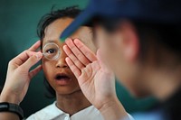 A patient looks through a lens to determine what prescription she needs for eyeglasses during Operation Pacific Angel 2013 in Dong Hoi, Quang Binh province, Vietnam, June 10, 2013.