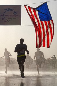 A U.S. Soldier crosses the finish line during a satellite version of the Atlanta Journal-Constitution Peachtree Road Race July 4, 2013, at Camp Leatherneck, Helmand province, Afghanistan.