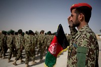 An Afghan National Army officer with the 215th Corps salutes passing troops during a ceremony commemorating the 94th anniversary of Afghanistan's independence from Britain at Camp Shorabak, Helmand province, Afghanistan, Aug. 19, 2013.