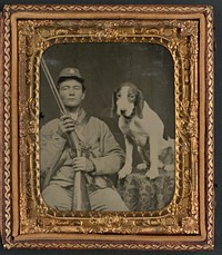 Unidentified soldier in Confederate uniform with shotgun sitting next to dog