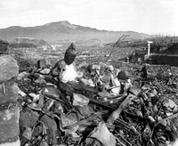 Battered religious figures stand watch on a hill above a tattered valley. Nagasaki, Japan. September 24, 1945, 6 weeks after the city was destroyed by the world's second atomic bomb attack. Photo by Cpl. Lynn P. Walker, Jr. (Marine Corps)