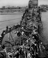 "Flight of Refugees Across Wrecked Bridge in Korea", photograph of refugees fleeing Pyongyang during the Korean War across a destroyed bridge over the Taedong River. This photograph was named as an exemplar of Desfor's work in his citation for the 1951 Pulitzer Prize for Photography.