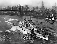 View of USS ARIZONA taken from Manhattan Bridge on the East River in New York City on its way back from sea trials. Note Christmas trees on both lookouts atop cage masts. December 25,1916.