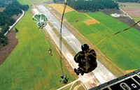 Naval Outlying Field Coupeville: Explosive Ordnance Disposal Mobile Unit Eleven (EODMU-11) members perform a static jump from the ramp of a C-130 Hercules, in groups of three. EODMU-11 is flying with the 731st Airlift Squadron and will descend from altitudes ranging from 1,000 to 13,000 feet. Their mission is to successfully exit the aircraft using proper parachuting procedures and hit their designated drop zone target. Each jumper must go through a series of safety checks before jumping, while being instructed by the jumpmaster, who is the most qualified jumper aboard the aircraft, and the only one who can give the okay to exit the aircraft.