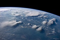 Thunderheads near Borneo, Indonesia are featured in this image photographed by an Expedition 40 crew member on the International Space Station.Crews aboard the International Space Station (ISS) have recently focused their cameras on panoramic views of clouds. Many of the photographs have been taken with lenses similar to the focal length of the human eye. Such images help us see Earth the way ISS crews see it from their perch 350 kilometers above—with a strong three-dimensional sense and a broad view of the planet.In this image, late afternoon sunlight casts long shadows from thunderhead anvils down onto southern Borneo. Near the horizon (image top center), more than 1000 kilometers away from the space station, storm formation is assisted by air currents rising over the central mountains of Borneo.Winds usually blow in different directions at different altitudes. At the time of this photo, high-altitude winds were clearly sweeping the tops off the many tallest thunderclouds, generating long anvils of diffuse cirrus plumes that trail south. At lower levels of the atmosphere, “streets” of white dots—fair-weather cumulus clouds—are aligned with west-moving winds. Small smoke plumes from forest fires in Borneo are also aligned west.Caption by M. Justin Wilkinson, Jacobs and Michael Trenchard, Barrios Technology at NASA-JSC