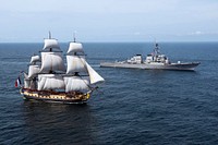 The Arleigh Burke-class guided-missile destroyer USS Mitscher (DDG 57), right, provides a warm welcome to the French tall ship replica Hermione in the vicinity of the Battle of Virginia Capes off the East Coast of the United States. The original Hermione brought French General Marquis de Lafayette to America in 1780 to inform Continental Army General George Washington that a French army was headed for the United States to assist in the war effort. The symbolic return of the Hermione will pay homage to Lafayette and the Franco-American alliance that brought victory at the Battle of Yorktown in 1781. The Hermione will visit Yorktown (Virginia) on 5 June and then continue up the East Coast visiting cities of Franco-American historical significance.