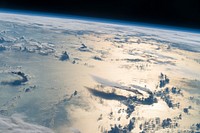 Flying over the Philippine Sea, an astronaut looked toward the horizon from the International Space Station and shot this photograph of three-dimensional clouds, the thin blue envelope of the atmosphere, and the blackness of space.