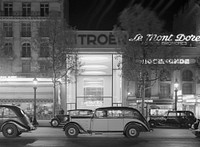 Cars on the Champs-Elysées, with the illuminated Citroën showroom in the background.
