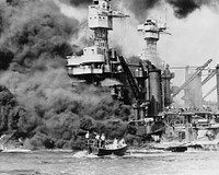 "Pearl Harbor, Hawaii. A small boat rescues a seaman from the 31,800 ton USS West Virginia (BB-48), which is burning in the foreground. Smoke rolling out amidships shows where the most extensive damage occurred. Note the two men in the superstructure. The USS Tennessee (BB-43) is inboard."