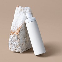 White spray bottle psd mockup against a rock