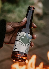 Label mockup on bottle psd being held by a man 