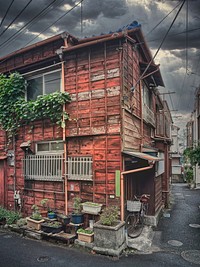 Aging House, Tokyo, JapanAging wooden house in a residential backstreet in central Tokyo, Japan. Window bars, creeper vines, and potted plants on the exterior.