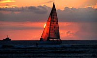 Sunset ocean scenery, sailboat, Hawaii.