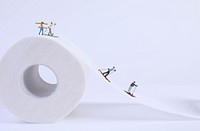 Miniature skiers skiing, toilet paper.