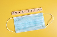 Medical face mask and Eurovision text on yellow background 